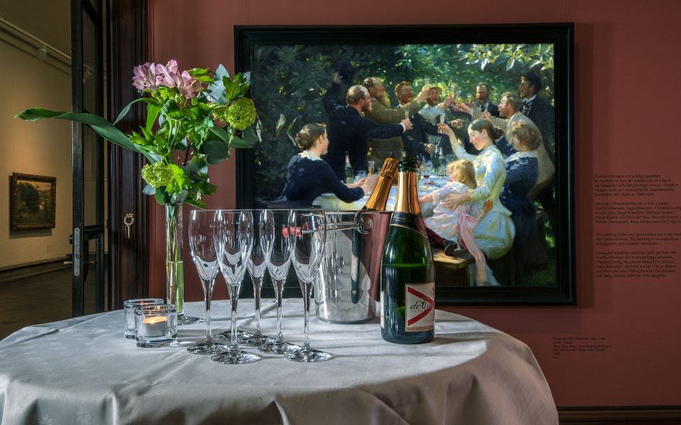 Runt bord med vit duk, dukat med champangeglas och flaska, blomsterbukett i vas. Målning bakgrunden.