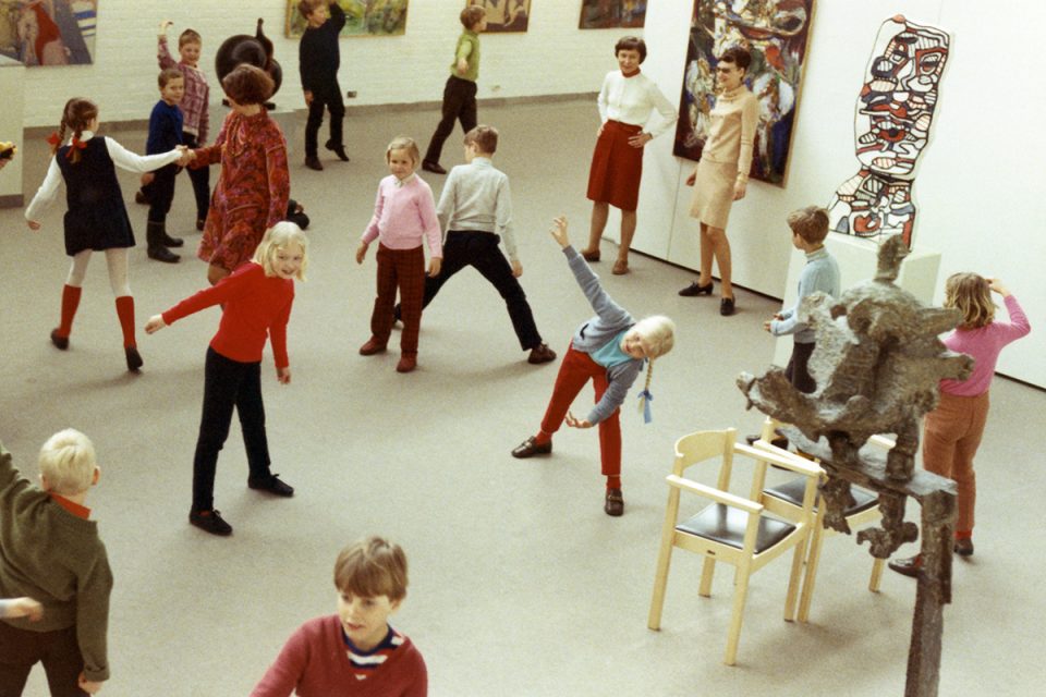 Museirum från 70-talet med många barn som gör olika rörelser.