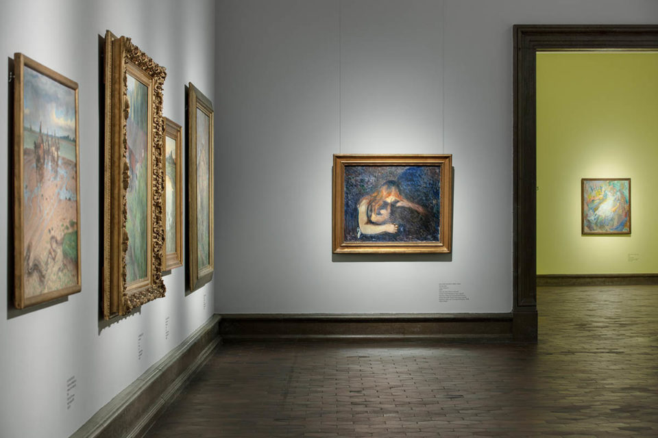 Väggar och dörröppning mellan museisalar. Målning i mörka färger av kvinna som lutar sig över och håller om en man.